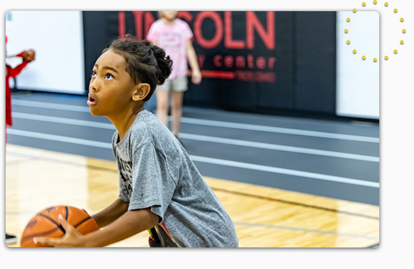 Child holding basketball about to make a shot