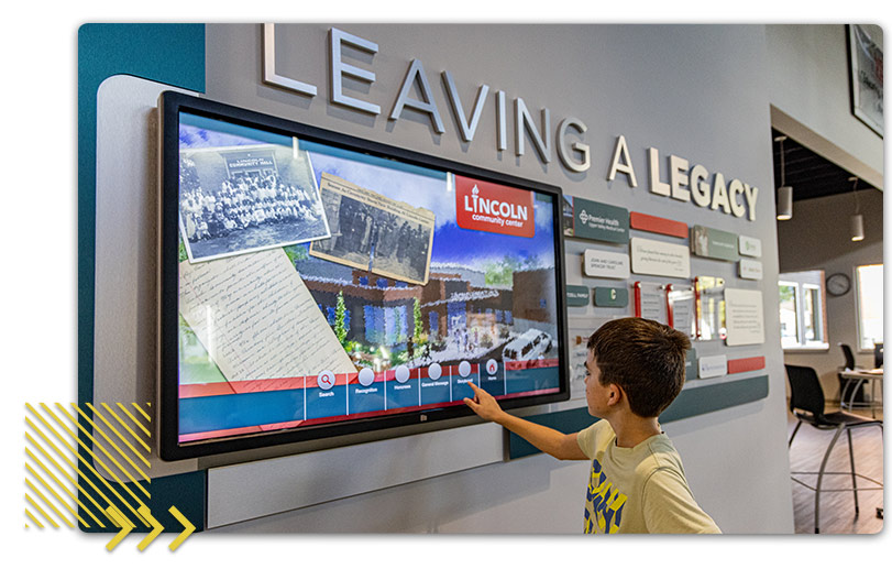 Boy using touchscreen display of Lincoln Community Center history