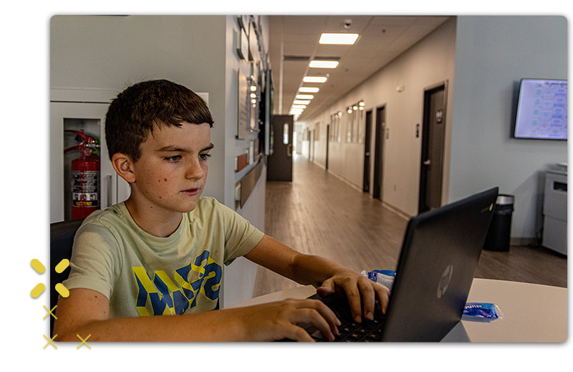 Boy using laptop at Lincoln Community Center